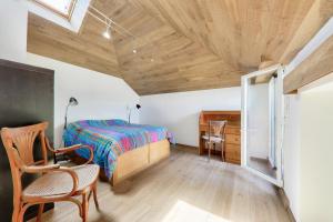 a bedroom with a bed and a wooden ceiling at Vue mer et acces plage direct pour 11 personnes in Saint-Gildas-de-Rhuys