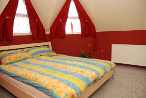 a bedroom with a bed with red walls and windows at Iso Apartman Siófok in Siófok