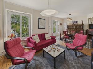 a living room with a red couch and chairs at Maison à 30m de la plage - Grand Jardin - pour 6 in Île-Tudy