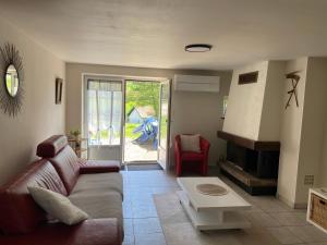 een woonkamer met een bank en een open haard bij Aux Trois Gîtes in La Chapelle