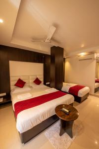 a bedroom with two beds and a coffee table at Hotel Horizon Hues in Port Blair +21 photos