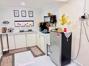 a kitchen with a refrigerator and a counter top at Abe.Cottage 2 in Kampung Kuala Besut