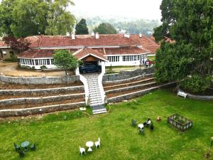 an aerial view of a house with people in a yard at The Tredis Heritage by the Lake in Kodaikānāl