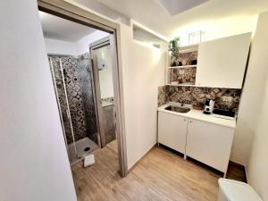a small kitchen with a sink and a shower at Nata Sicula in Syracuse