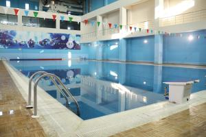 a large swimming pool with flags on the wall at Arena Hotel Tartar in Terter