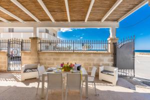 a patio with a table and chairs and a fence at La Casa di Palma by BarbarHouse in Torre Ovo