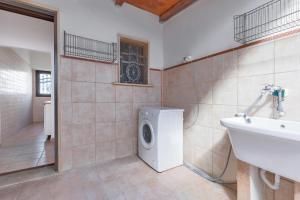 a bathroom with a washing machine and a sink at La Casa di Palma by BarbarHouse in Torre Ovo +9 photos