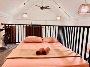 a large bed with two pillows and a ceiling at Abe.Cottage 2 in Kampung Kuala Besut