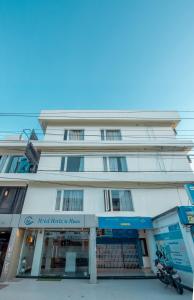 a white building with a motorcycle parked in front of it at Hotel Horizon Hues in Port Blair