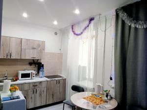 a small kitchen with a table and a microwave at Family Home in Petropavlovsk