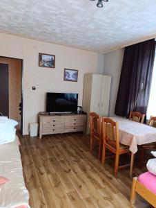a bedroom with a tv and a table and chairs at Miętowa Przystań in Mielno