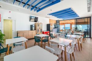 a restaurant with tables and chairs in a room at Hotel Cala Arena in San José