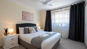 a bedroom with a large bed and a window at Coastal Crush in Callala Beach