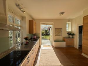 a large kitchen with a counter and a sink at Spacious Falsterbo Villa - Garden, BBQ, Bikes in Skanör med Falsterbo