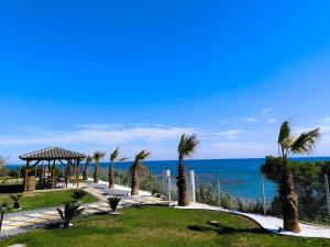 a pathway with palm trees and the ocean at Ataraxia Homes in Alexandroupoli