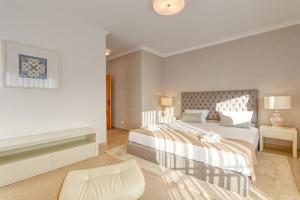 a bedroom with a large white bed and a fireplace at Praia D'el Rey - A4 in Óbidos
