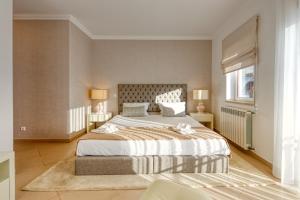 a bedroom with a large bed and a window at Praia D'el Rey - A4 in Óbidos