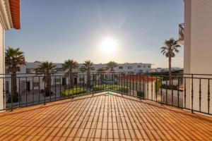 a balcony with a view of a building and palm trees at Praia D'el Rey - A4 in Óbidos +35 photos