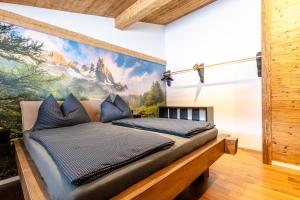 a bed in a room with a painting on the wall at Appartement Hoamatgfüh in Saalbach-Hinterglemm