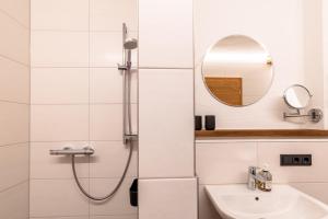 a white bathroom with a shower and a sink at Appartement Hoamatgfüh in Saalbach-Hinterglemm