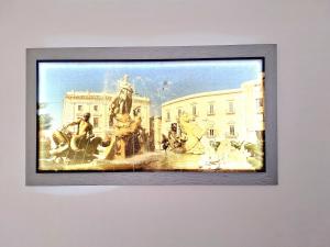 a painting of a fountain in front of a building at Nata Sicula in Syracuse +13 photos