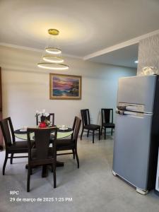 a dining room with a table and a refrigerator at Casa Nova Temporada Barreirinhas Lençóis Maranhense in Barreirinhas