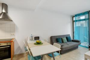 ラスパルマス・デ・グランカナリアにあるCasa Bonny Las Palmasのソファとテーブルのあるキッチンとリビングルーム