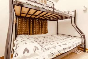 マニラにある2 BR condo trees residences Netflix Games karaokeのベッドルーム1室(白いベッドカバー付きの二段ベッド1組付)