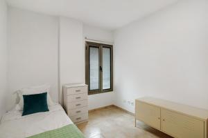 ラスパルマス・デ・グランカナリアにあるCasa Bonny Las Palmasのベッドとドレッサーと窓のある寝室