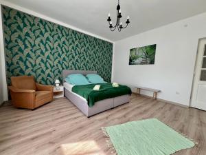a bedroom with a bed and a couch and a chair at AranyLak vendégház in Abádszalók
