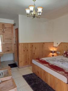 Habitación grande con cama grande y lámpara de araña. en Hotel Hadimba Heights, en Manali