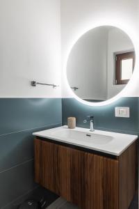 un bagno con lavandino e specchio di Baita di Teto a Roccaraso Altre 16 foto