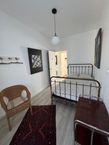 a bedroom with a bed and a chair and a table at Cottage-Saint Laurent sur Sèvre in Saint-Laurent-sur-Sèvre