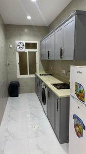 a kitchen with a refrigerator and a washer and dryer at شقق الستين بارك in Khamis Mushayt