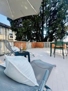 a patio with an umbrella and chairs and a table at Welcome Traveller GARDA VIBES in Garda +8 photos