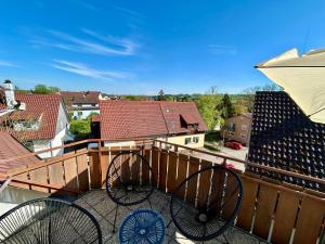 a balcony with two chairs and a view of houses at Ferienwohnung "Ruhe und Weitblick" Perfekte Anbindung in Illingen