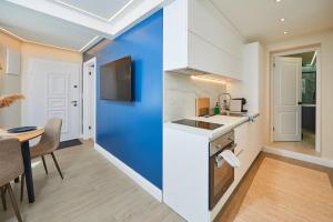 a kitchen with a blue wall and a table at Apartment Ivan in Pomorie +5 photos