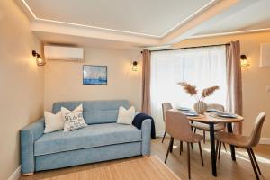 a living room with a blue couch and a table at Apartment Ivan in Pomorie