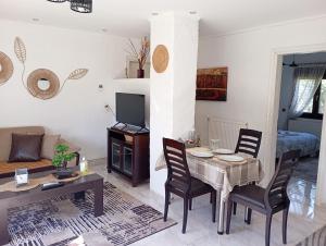 a living room with a table and chairs and a couch at Oasis Cottage in Krepeni +19 photos