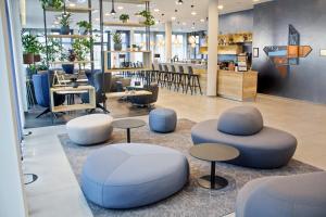 a lobby with tables and stools and a bar at Four Points Flex by Sheraton Bochum in Bochum
