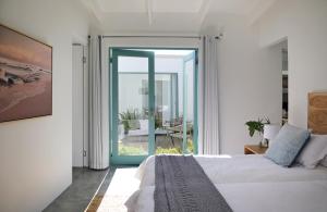 a bedroom with a bed and a sliding glass door at The Cottage Collection Paternoster in Paternoster +37 photos
