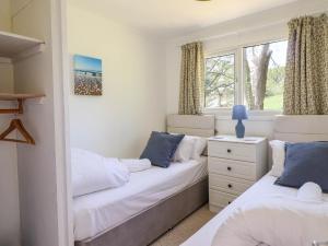 two beds in a room with two windows at Hill View in Tywyn