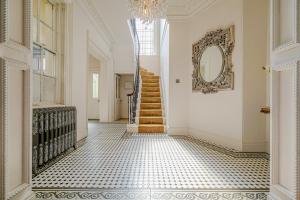 a hallway with a staircase and a mirror on the wall at Luxury Villa - City Centre - Sleeps 13 in Nottingham