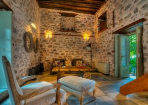 a living room with a couch and a table and chairs at Cotommatae Hydra 1810 in Hydra