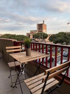 a wooden table and two benches on a balcony at Le Ciminiere Rooms in Catania