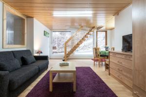 a living room with a couch and a staircase at Landpension Am Sommerhang in Bad Rippoldsau