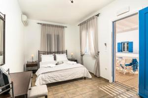 een witte slaapkamer met een bed en een tafel bij Livanios Studios in Adamas +49 foto's