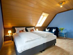 a bedroom with a large bed with a wooden ceiling at Landpension Am Sommerhang in Bad Rippoldsau