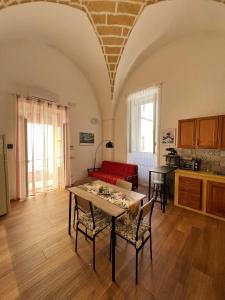 a living room with a table and a red couch at Kaléa Gallipoli in Gallipoli