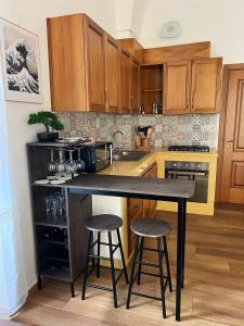 a kitchen with wooden cabinets and a island with bar stools at Kaléa Gallipoli in Gallipoli +20 photos